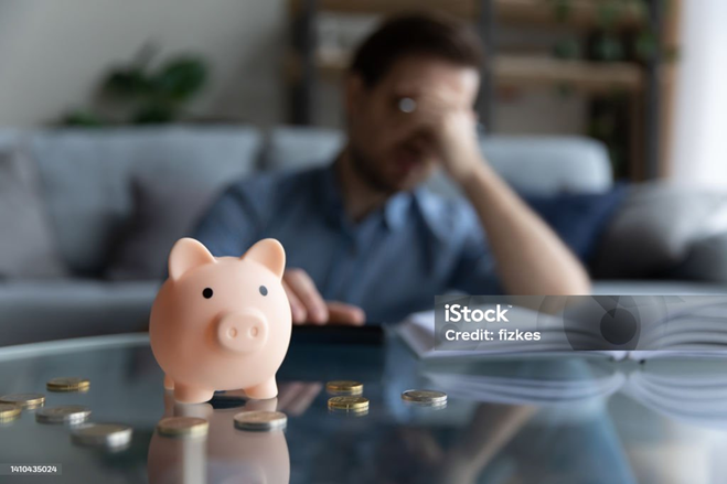 Young man feeling stressed calculating expenditures or taxes.